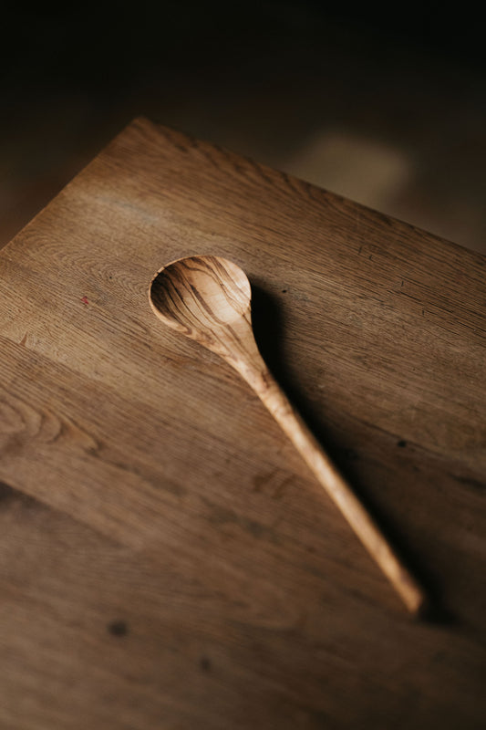 Olijfhouten kooklepel met een ronde handgreep.