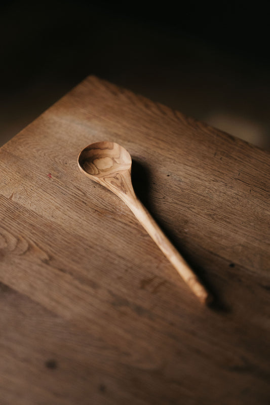 Olijfhouten kooklepel met een ronde handgreep.